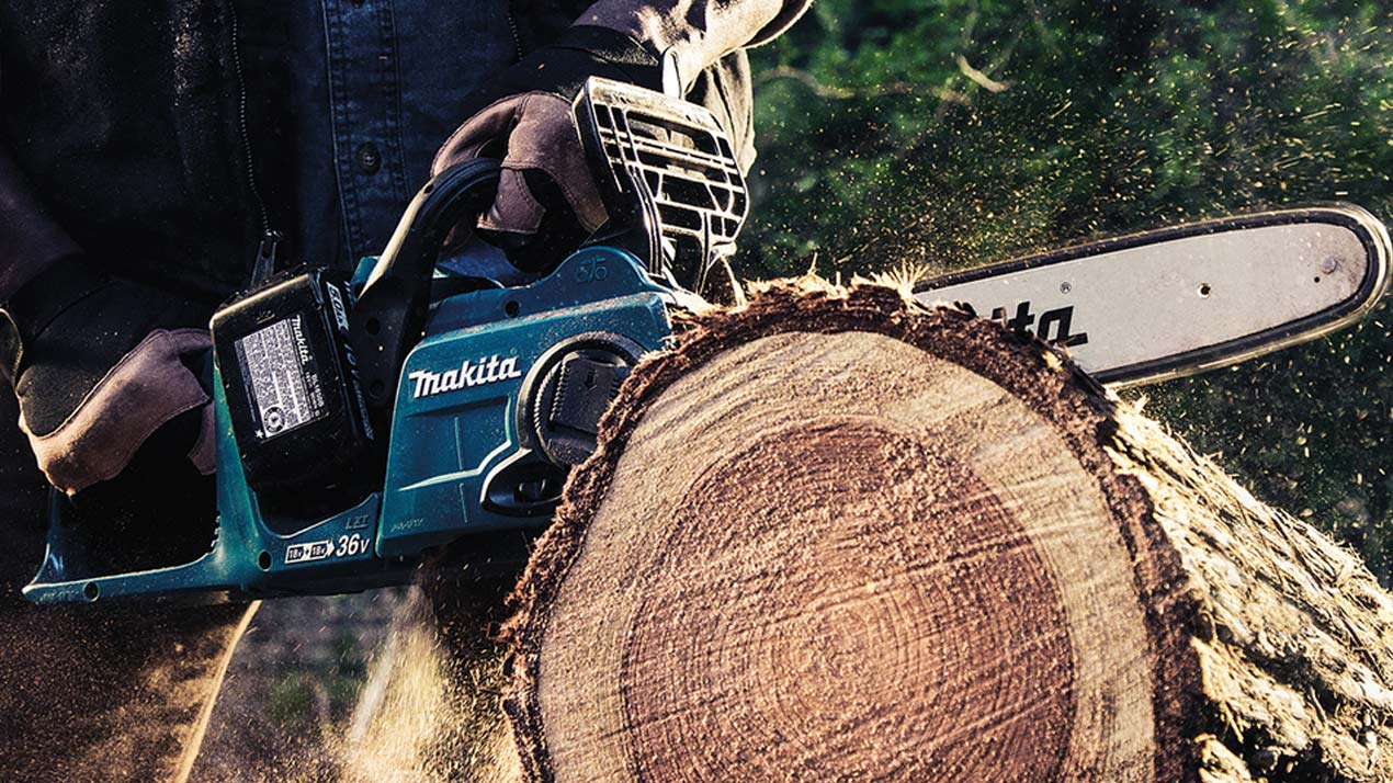 Makita motorsav der skærer træstamme i stykker